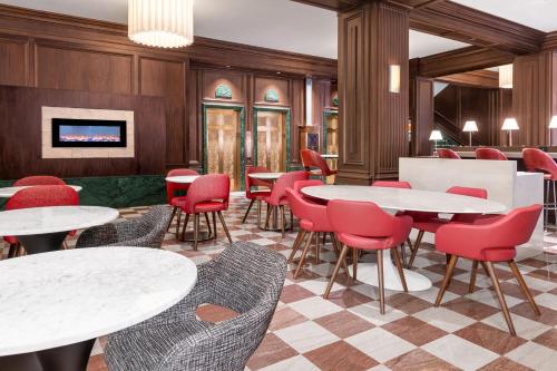 a restaurant with white tables and red chairs at Courtyard St. Louis Downtown/Convention Center in Saint Louis