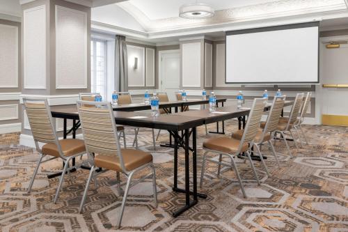 a conference room with a table and chairs and a white screen at Courtyard St. Louis Downtown/Convention Center in Saint Louis