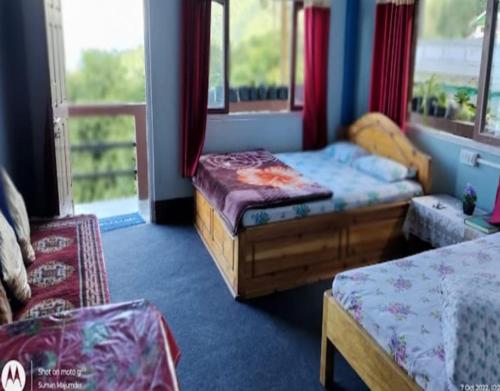 a room with two beds and a window at Simma Homestay By StayApart in Pedong