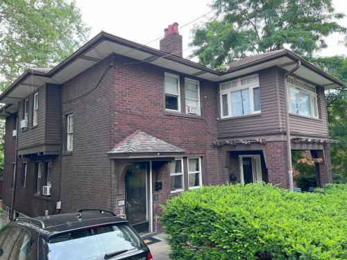 a house with a car parked in front of it at Charming 3 Bedroom Cottage Apartment in a Tudor-Style Home in Pittsburgh