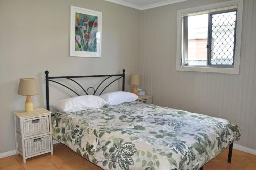 Un dormitorio con una cama y dos lámparas y una ventana. en Five On Trial - Bring your own linen, en South West Rocks