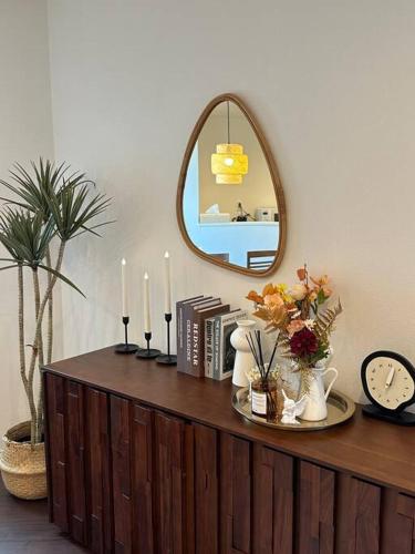 a mirror on top of a wooden cabinet with candles at Osaka KyoSai-B 洁兮 in Osaka