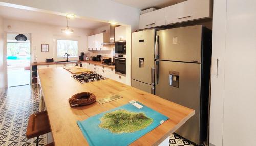 a kitchen with a wooden table and a refrigerator at COLIVER - COLIVING A LA RÉUNION in Saint-Pierre