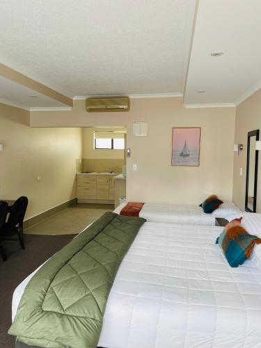 a bedroom with two large white beds in it at Kauri Court Motel and Apartments in Palmerston North