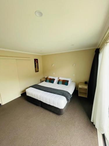 a bedroom with a large bed in a room at Kauri Court Motel and Apartments in Palmerston North