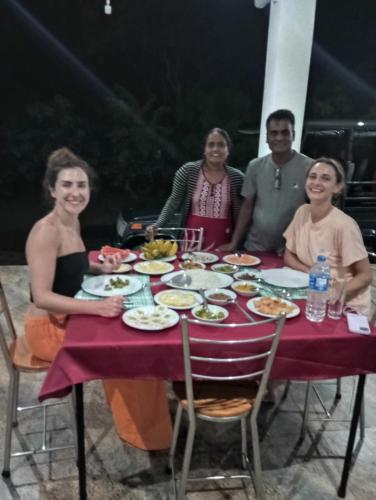 a group of people sitting around a table with food at Jungle Lodge in Udawalawe