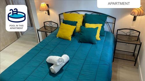 a bed with blue sheets and yellow pillows at Sam & Chlo Studio & Appartment - Grand Baie - Mauritius in Grand Baie