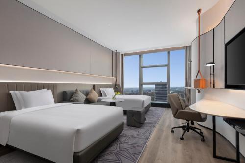 a hotel room with a bed and a desk at Crowne Plaza Taizhou City Center by IHG in Taizhou