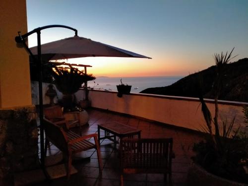 a patio with a table and chairs and an umbrella at Contrada Cafaro in Salerno