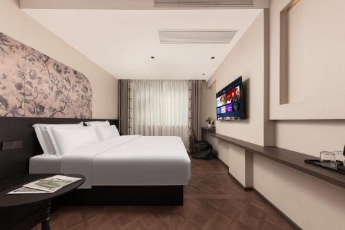 a bedroom with a large white bed and a tv at 木桃酒店Mutao Hotel in Hangzhou