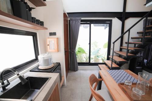 a kitchen with a sink and a counter with a table at Ubu Villa Alston in Yogyakarta in Yogyakarta