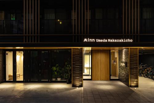 una entrada a un edificio de apartamentos por la noche en Minn Umeda Nakazakicho, en Osaka