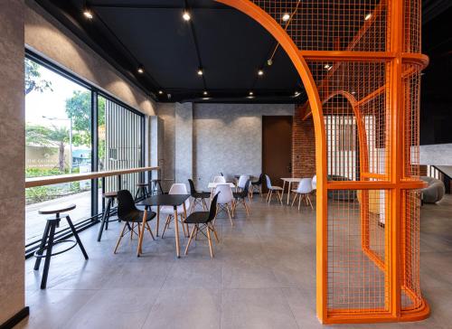 a dining room with tables and chairs and a large window at The Hammock Hotel Global City in Ho Chi Minh City