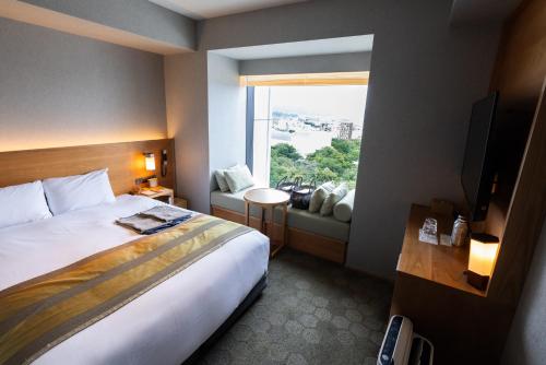 pokój hotelowy z łóżkiem i oknem w obiekcie Fujisan Mishima Tokyu Hotel w mieście Mishima