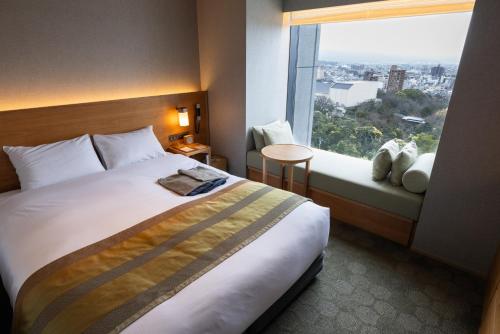 a hotel room with a large bed and a window at Fujisan Mishima Tokyu Hotel in Mishima