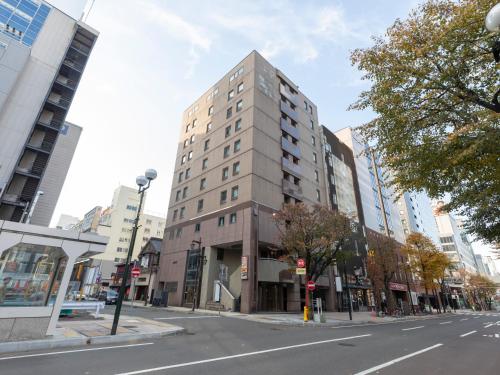 a tall building on the corner of a city street at Tabist THE GREEN SAPPORO in Sapporo