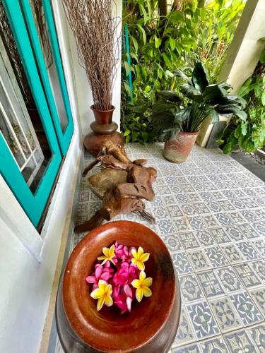 a bowl filled with flowers on a floor next to a door at Frangipani garden villa in Senggigi 