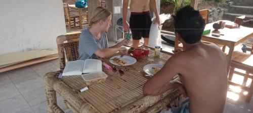a man and a woman sitting at a table at Melody Ekas Lombok in Ekas