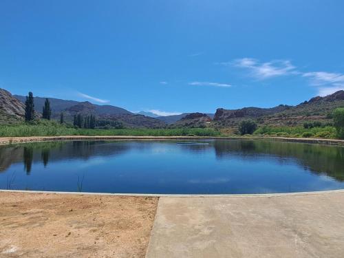 a large pond of water with mountains in the background at Red Ridge Mountain Lodge in Buffelskloof