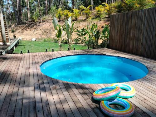 a swimming pool with four colorful inflatables in a yard at Private Bush & Beach Retreat in Eudlo