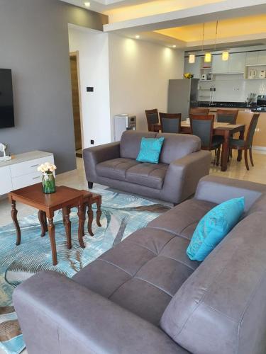 a living room with two couches and a table at The Heart of Urban in Nairobi