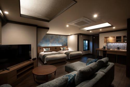 a hotel room with two beds and a television at まち宿 壱龍 MACHIYADO ICHIRYU in Takayama