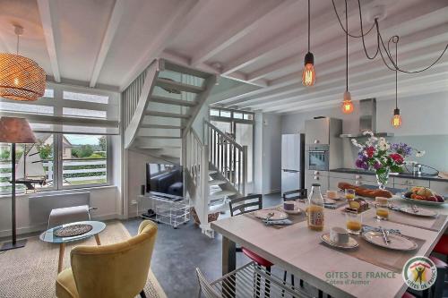 une cuisine et un salon avec une table et des chaises dans l'établissement Les flots, à Gicquel