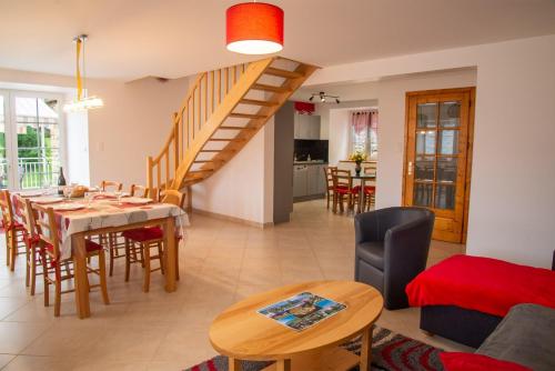 a living room with a dining room table and a staircase at Gite b les pres in Chadenet