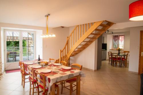 a dining room with a table and a staircase at Gite b les pres in Chadenet
