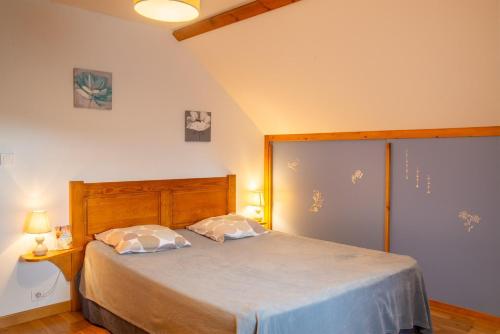 a bedroom with a bed with two pillows on it at Gîte a les rosiers in Chadenet