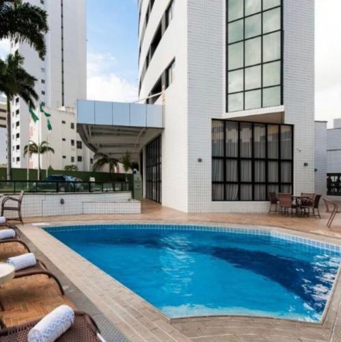 a swimming pool in front of a building at NATAL PLAZA PONTA NEGRA in Natal