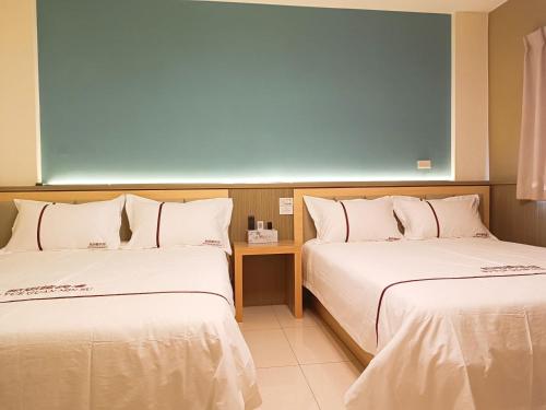 two beds sitting next to each other in a room at 鉑玥館民宿 in Jinning