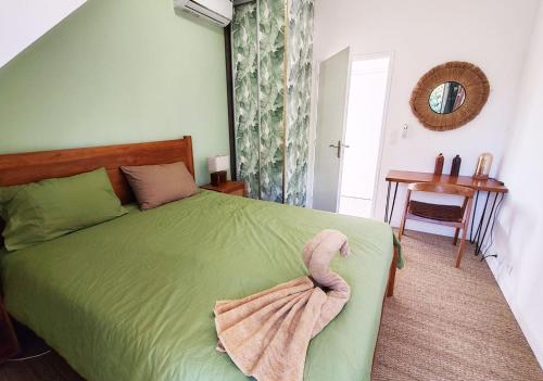 a bedroom with a green bed with a towel on it at COLIVER - COLIVING A LA RÉUNION in Saint-Pierre