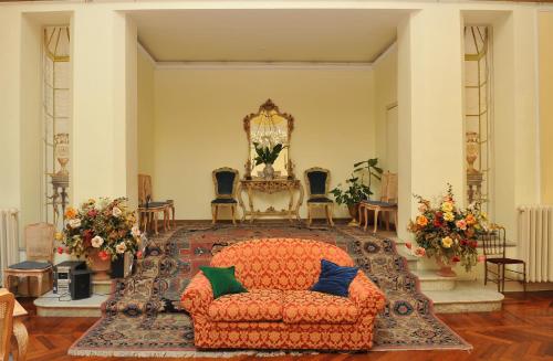 a living room with an orange couch and a chair at Grande Albergo Quattro Stagioni in Rieti