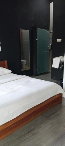 a bedroom with a bed and a bathroom with a sink at Mercusuar Resort Jepara in Kesembu