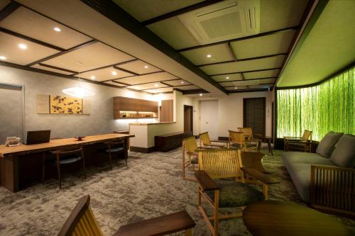 a waiting room with a couch and tables and chairs at まち宿 壱龍 MACHIYADO ICHIRYU in Takayama