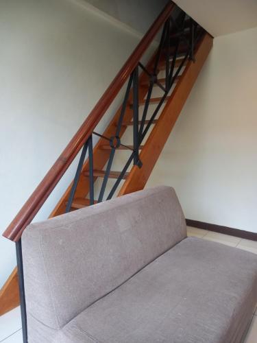 a stair case with a couch in a room at Song Service Apartment formerly known as Jinhold Service Apartment in Kuching