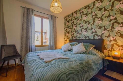 a bedroom with a bed with a floral wall at La grande sablonniere in La Ville-aux-Bois