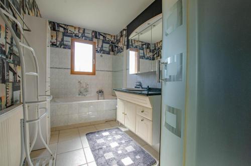 a bathroom with a tub and a sink at La grande sablonniere in La Ville-aux-Bois