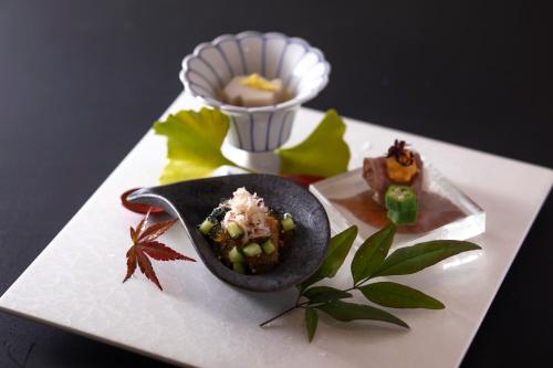 a white plate with some food on top at まち宿 壱龍 MACHIYADO ICHIRYU in Takayama