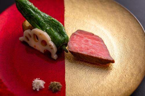 a plate of food with a piece of meat and vegetables at まち宿 壱龍 MACHIYADO ICHIRYU in Takayama