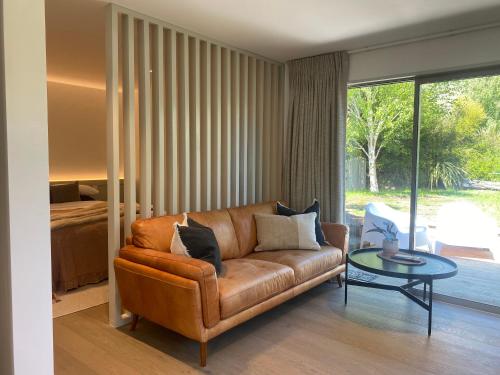 a living room with a brown couch and a glass table at Morning Star Studio A in Queenstown