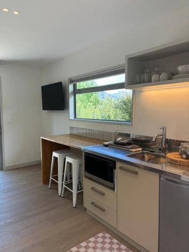 a kitchen with a sink and a counter with a window at Morning Star Studio A in Queenstown