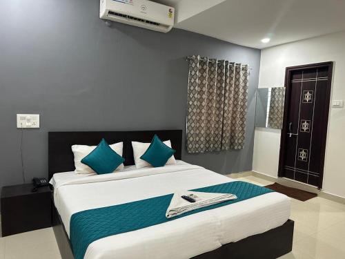 a bedroom with a large bed with blue pillows at Hotel Deccan Retreat in Hyderabad