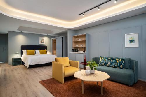 ケープタウンにあるThe Quarter Apartmentsのベッドとソファとテーブルのある寝室