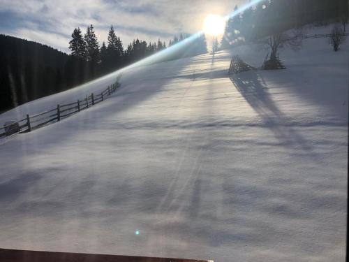 a snow covered slope with the sun shining on it at Перлина Гір in Yablunytsya