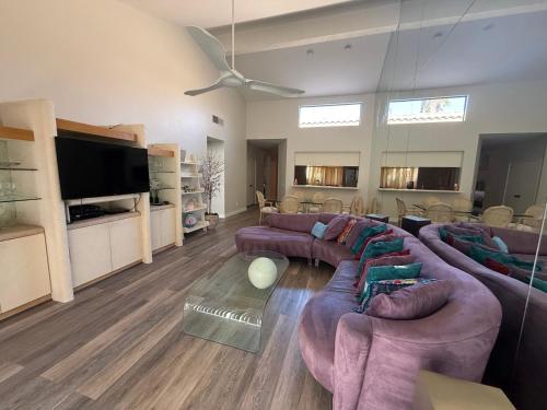a large living room with couches and a flat screen tv at Palm Valley Country Club, Pickleball, Tennis, Gym, Clubhouse, Swimming Pools, Lux, Spac 2 Bdrms Den 2 Ba in Palm Desert