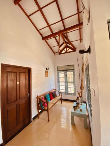 a living room with a wooden door and a couch at Coco Bliss - Ahangama in Ahangama