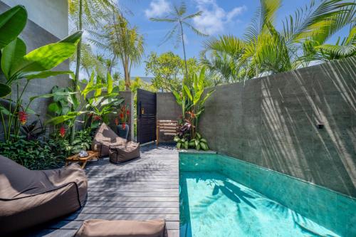 einen Pool im Hinterhof mit Palmen in der Unterkunft Umalas Creek Villas in Canggu