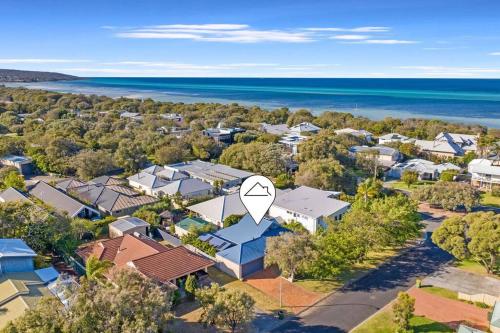 an aerial view of a suburb with a house with a white arrow at Meters to Beach, Walk to Town! in Quindalup